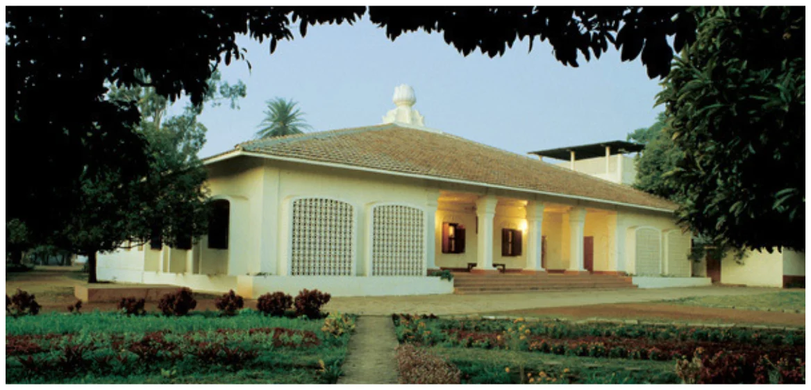 Fotografía del edificio Yogoda Satsanga Branch Math rodeado de jardines.